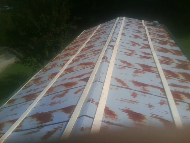 Rusted metal roof panels with new wood purlins before replacement — Storm Damage Roof Repair in Bladenboro by Roofing Brothers