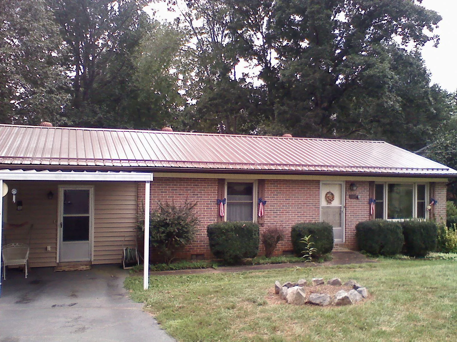 Bronze metal roof and carport on a brick ranch home — Roof Repair work by our crew in Bladenboro
